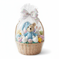 Easter basket gift set with crochet teddy bear in blue pajamas, eggs, and toys wrapped in cellophane with bow